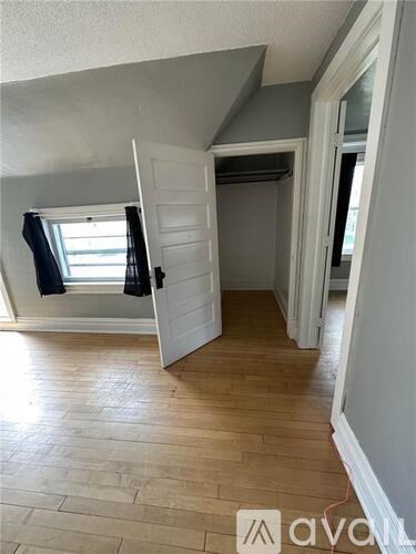 A room with wooden flooring and a white door.