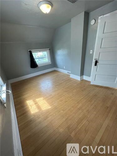 A room with wooden flooring and a white door.