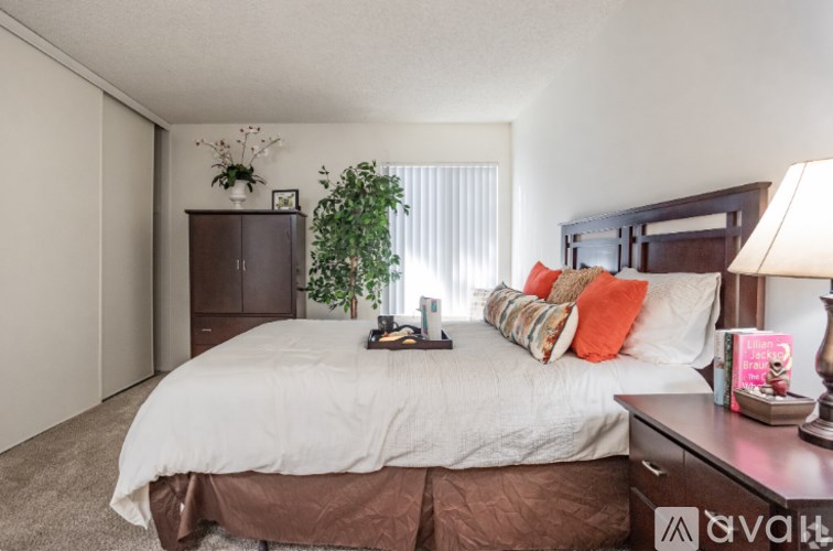 A bedroom with a large bed and a wooden cabinet.