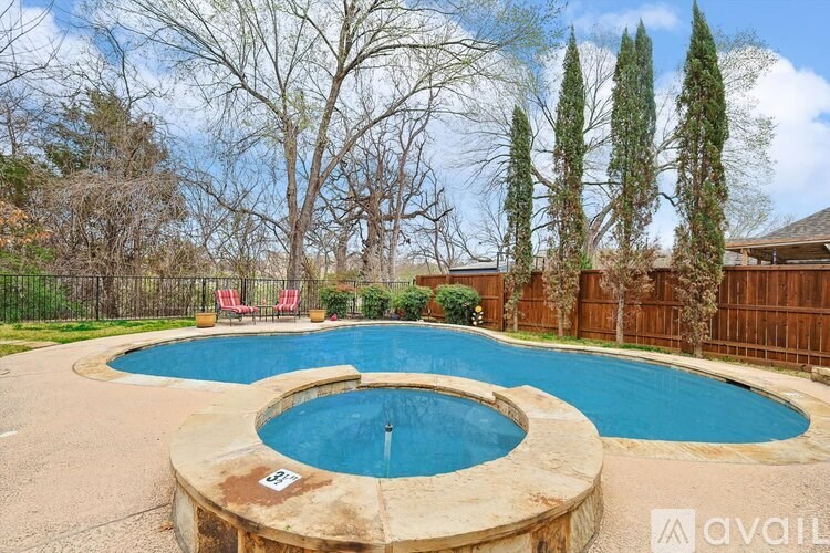 A backyard with a round pool and a fence.