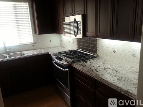 A kitchen with a stove top oven and a window.