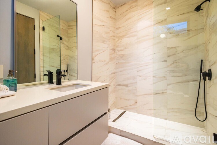 A bathroom with a marble wall and a walk-in shower.