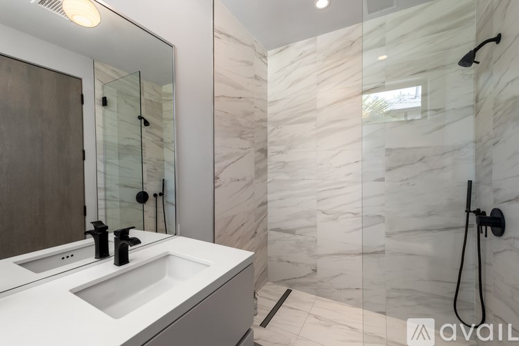 A bathroom with a marble wall and a white sink.