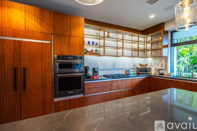 A kitchen with wooden cabinets and a marble countertop.