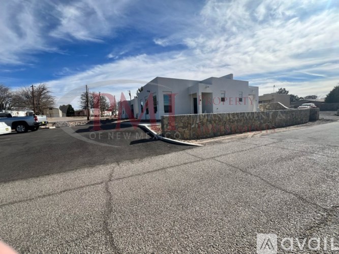 A white building with the word "PROPERTY" on it is surrounded by a stone wall.