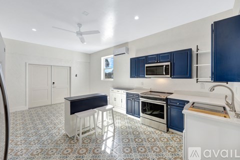 A kitchen with blue cabinets and a white countertop.