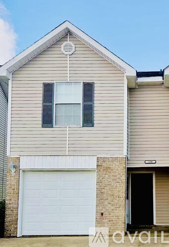 A two-story house with a white car parked in front.