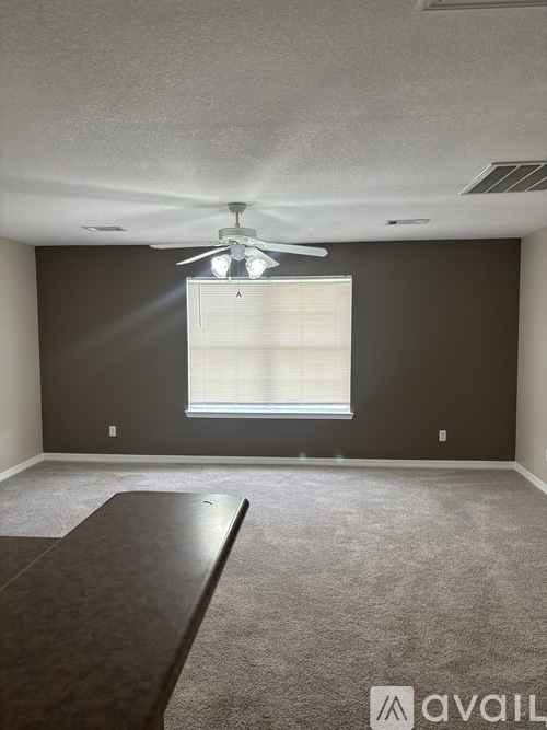 A bedroom with a large bed, a television, and a ceiling fan.
