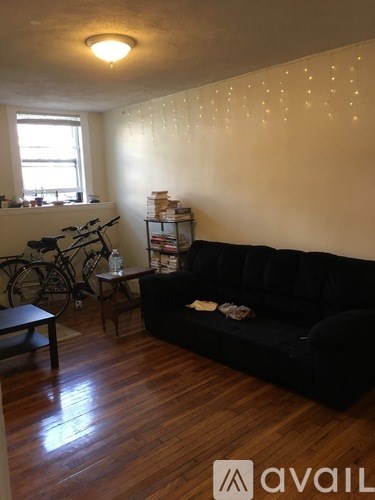 A living room with a black couch and a bicycle.