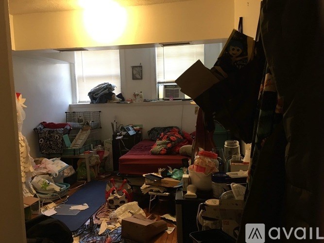 A messy room with a bed, a desk, and various items scattered about.