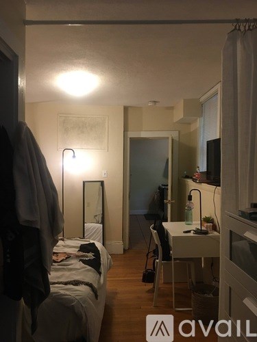 A bedroom with a bed, desk, and chair.