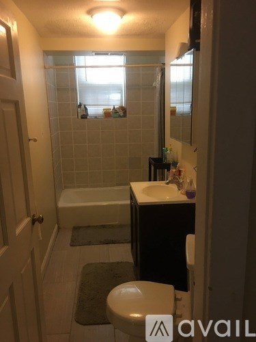 A bathroom with a toilet, sink, and bathtub.