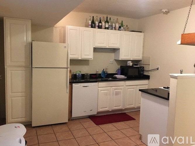 A kitchen with white cabinets and a black countertop.