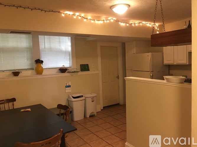 A kitchen with a table, chairs, and a refrigerator.