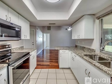 A kitchen with white cabinets and a granite countertop.