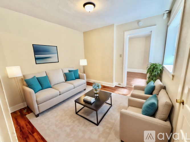 A living room with a couch, a coffee table, and a painting on the wall.