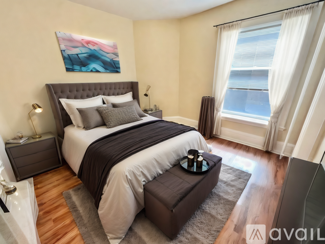 A bedroom with a large bed and a painting on the wall.