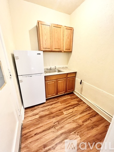 A kitchen with wooden floors and white appliances.