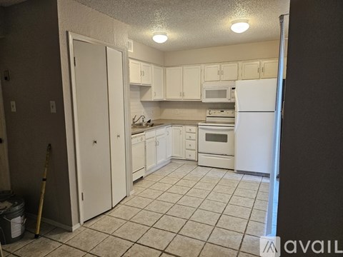 A kitchen with white appliances and cabinets.