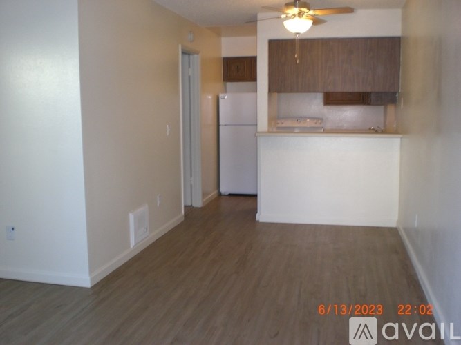 A room with a refrigerator and a ceiling fan.