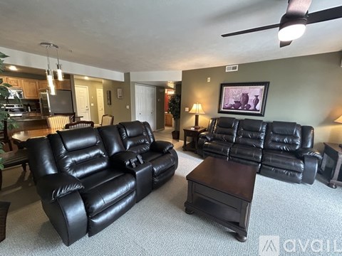 A living room with two black leather couches and a coffee table.