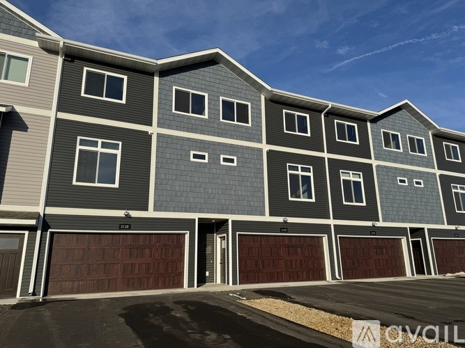 A modern apartment building with a clear blue sky in the background.