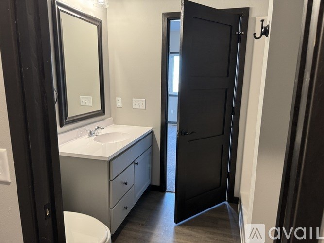 A bathroom with a sink, mirror, and toilet.