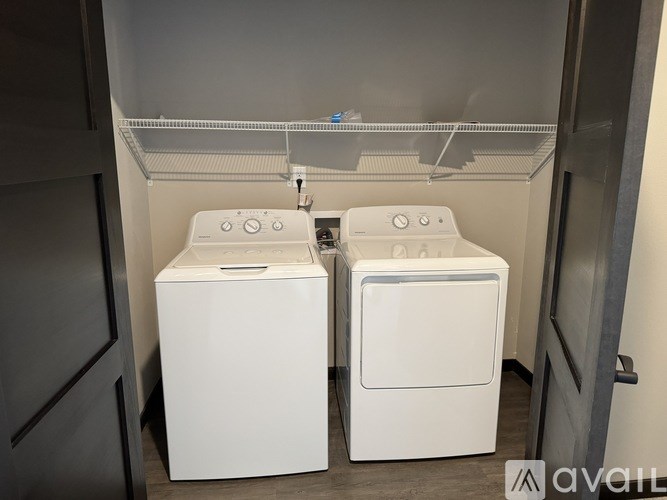 Two white front loading washing machines in a laundry room.
