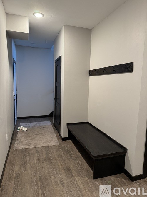 A hallway with a bench and a door.