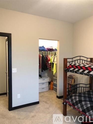 A bedroom with a bed, a wardrobe, and a mirror.