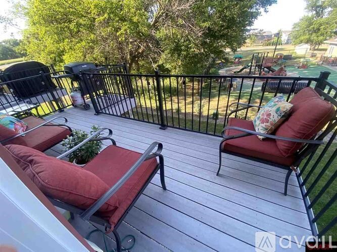 A deck with two chairs and a table.