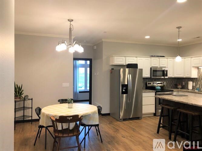 A kitchen with a table and chairs in the middle of the room.