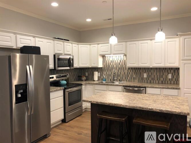 A kitchen with a granite countertop and stainless steel appliances.