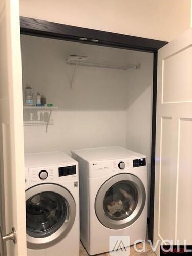 Two front loading washing machines in a small laundry room.