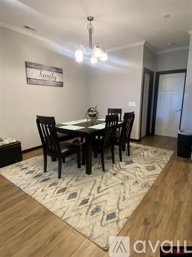 A dining room with a table and chairs.