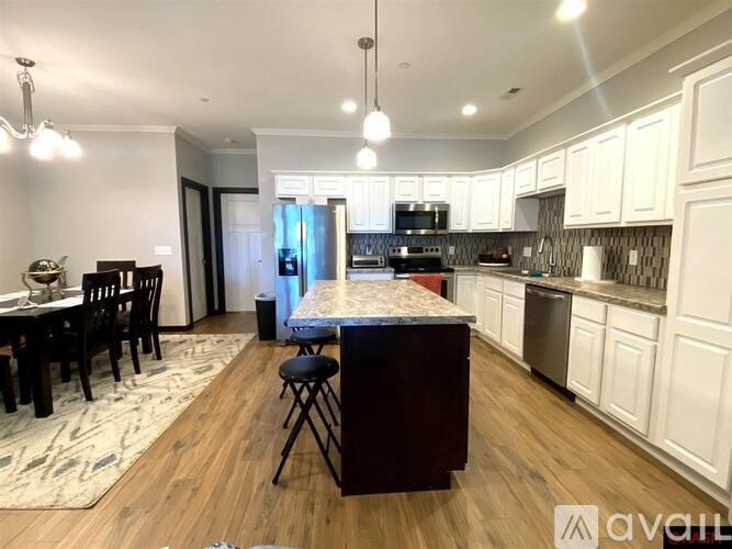 A kitchen with a table and chairs in the middle of the room.