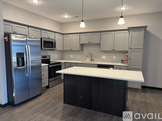 A kitchen with a white countertop and stainless steel appliances.