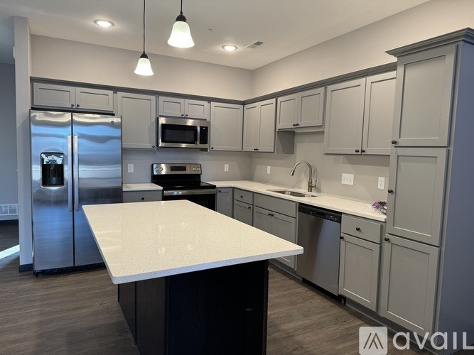 A kitchen with a white countertop and stainless steel appliances.