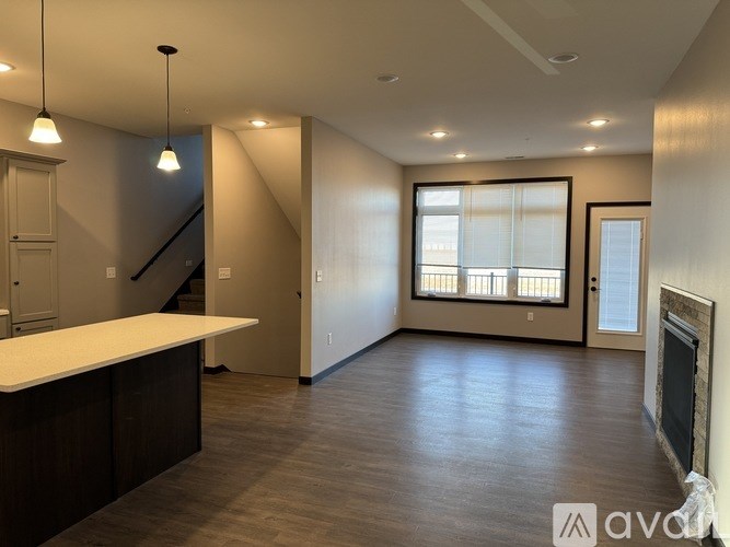 A spacious living room with a staircase and a fireplace.