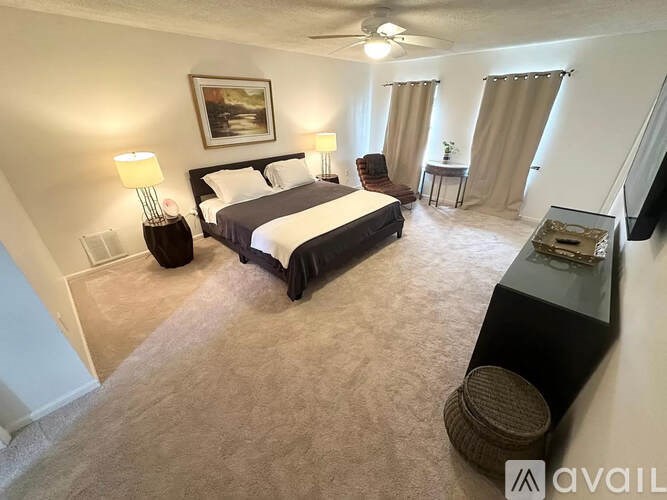 A bedroom with a large bed and a painting on the wall.