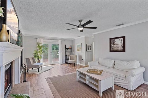 A living room with a white couch and a fireplace.