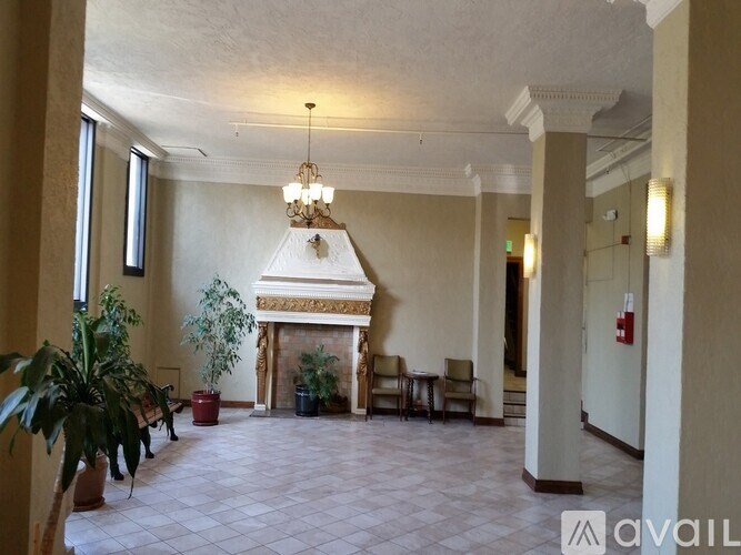 A large room with a fireplace and chairs.