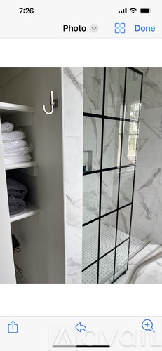 A white towel is hanging on a hook on a white door.