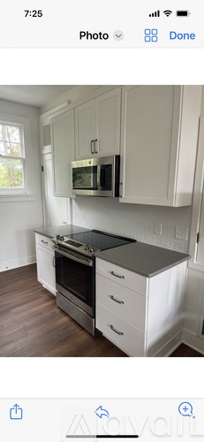 A kitchen with white cabinets and a black countertop.