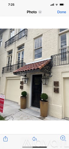 A building with a black door and a red awning.