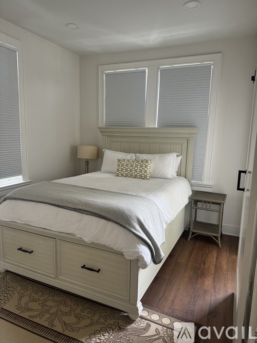 A bedroom with a large bed and a small table.