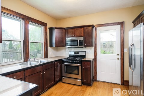 A kitchen with wooden cabinets and a stainless steel refrigerator.