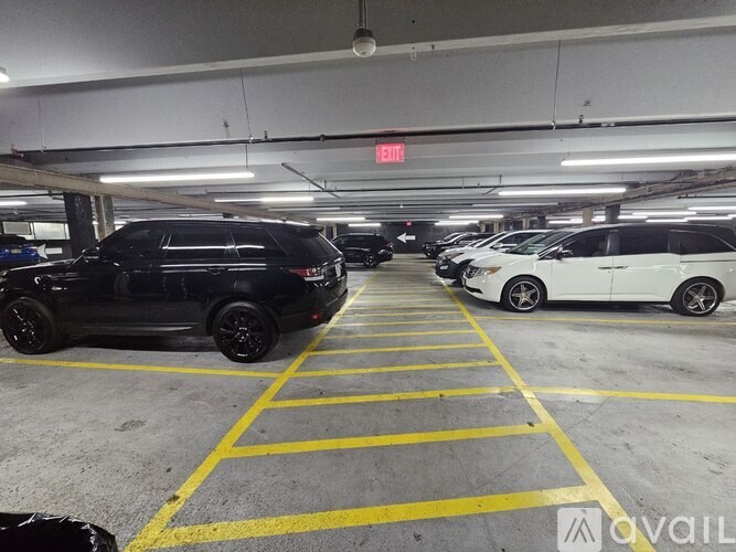 A parking garage with a black SUV and a white minivan parked in the spaces.