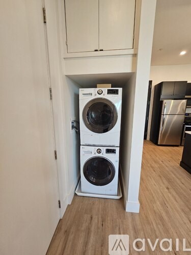 Two washing machines are stacked in a small space.