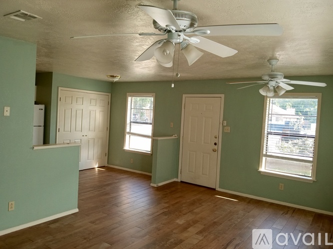 A room with a ceiling fan and two doors.